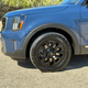 Close-up image of the left front wheel and tire on a blue 2023 Kia Telluride SX X-Pro